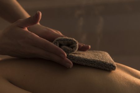 close-up-therapist-massaging-woman-s-back-with-hot-towel-beauty-spa
