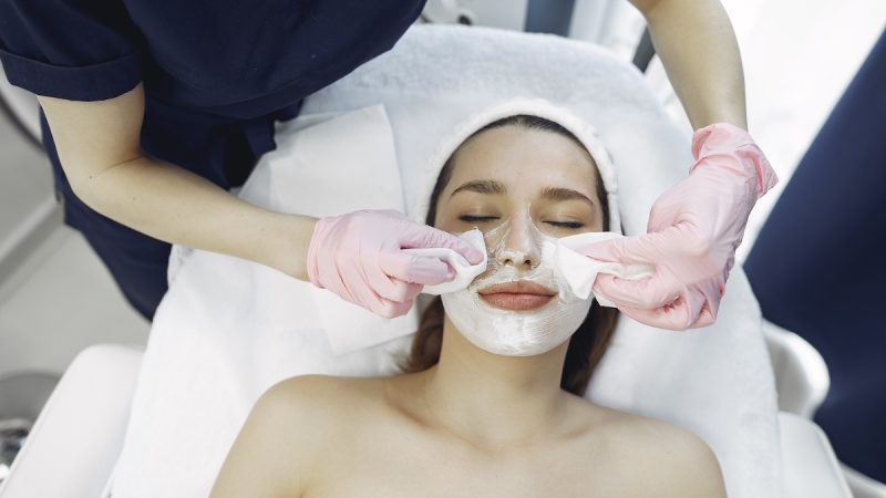 Cosmetologist treats client's skin. Woman with cosmetologist. Lady in a beauty studio.